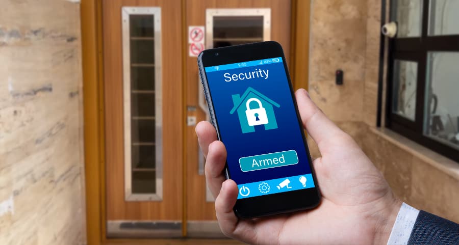 Man using cell phone to arm a security system